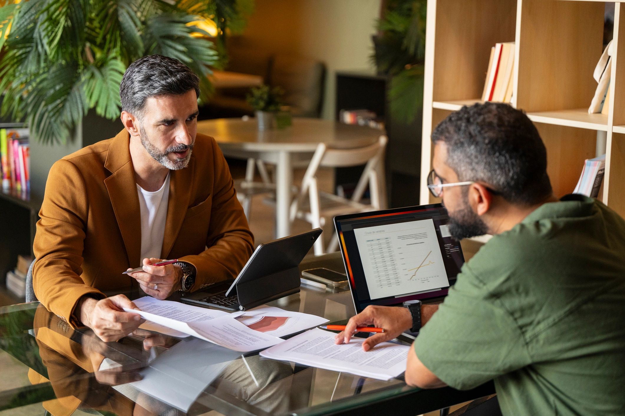 Two business professionals reviewing financial documents in a meeting